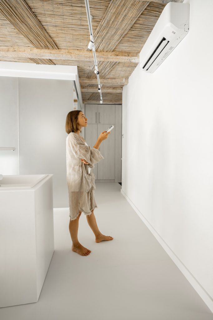 woman sets the temperature on the air conditioner 2023 11 27 05 25 40 utc Aire Acondicionado La Herradura