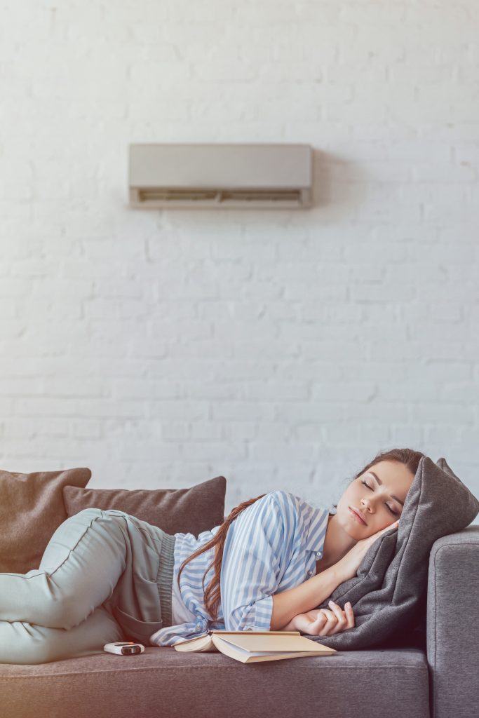 woman sleeping on sofa with book and air condition 2023 11 27 05 23 57 utc Aire Acondicionado Frigiliana